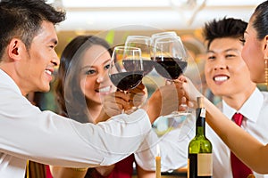 Chinese couples toasting with wine in restaurant