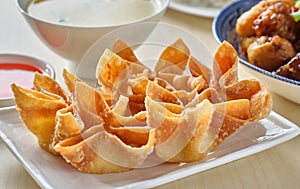 Chinese crab rangoon fried wontons on plate with red sauce