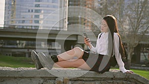 Chinese cute girl is chating on cell phone. Female is nodding in likely pose.