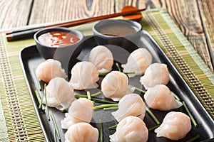 Chinese dim sum Har Gow dumplings with shrimp served with sauce closeup. Horizontal