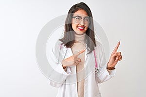 Chinese doctor woman wearing coat and pink stethoscope over isolated white background smiling and looking at the camera pointing
