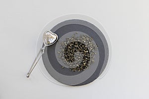 Chinese Dragon pearl Jasmine Green tea leaves rolled in spiral. Tea steeper and green snail tea balls photo