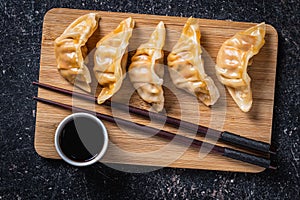 Chinese dumplings abd soy sauce on cutting board
