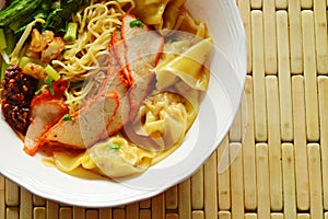 Chinese egg noodle topping slice barbecue pork and dumpling in soup