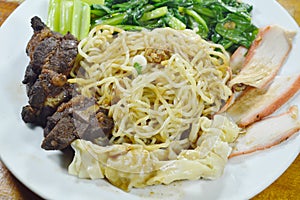 Chinese egg noodles topping slice barbecue pork and braised rib with dumping dressing sweet black sauce on plate