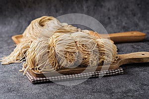 Chinese egg noodles on Wooden Cutting board.