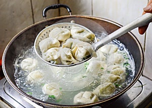 Chinese Family Cooking Boiled Dumplings in Wok