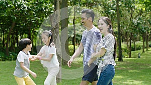 Chinese family enjoying weekend activity in park in summer