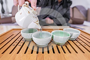 The Chinese family making tea at home with traditional tea set and colorful tea cup