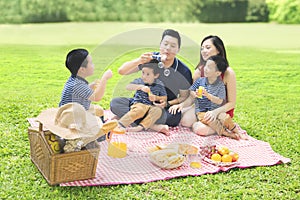 Chinese family playing with bubble soap in park