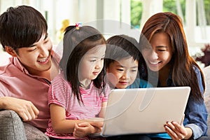 Chinese Family Using Laptop Whilst Relaxing