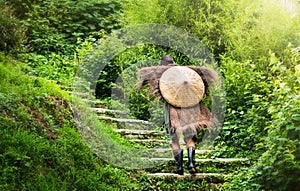 Chinese farmer in antique raincoat walking up stairs