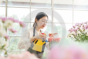 Chinese Female florist spraying water on bouquet of flowers