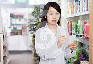 Chinese female pharmacist working in pharmacy