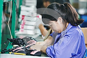 Chinese female worker in assembling electronic device on factory