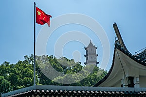 The Chinese flag fluttering in the wind with the West Pagoda on the Jiangxin island in Wenzhou in China in the background