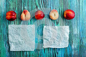 Chinese flat peaches and nectarins on rustic colorful background with copy space. Flat lay background.