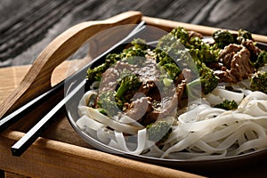 Chinese food - beef prepared with broccoli and rice noodles.