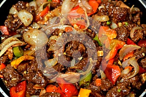 Chinese food cuisine of grilled beef red meat pieces and cubes with oil, mushroom, vegetables, peas, carrots, colorful peppers,