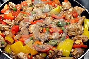 Chinese food cuisine of grilled chicken breast pieces and cubes with oil, mushroom, vegetables, peas, carrots, colorful peppers,
