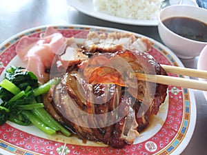 Chinese food style, Selective focus of chopsticks holding roasted duck in restaurant
