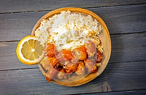 Chinese Food Sweet and Sour, Orange or Lemon Chicken with rice in wooden bowl on rustic table