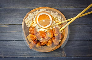 Chinese Food Sweet and Sour, Orange or Lemon Chicken with rice in wooden bowl on rustic table