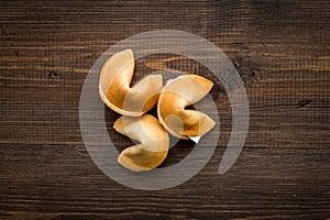 Chinese fortune cookie with prediction on wooden background top view space for text