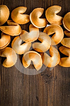 Chinese fortune cookie with prediction on wooden background top view space for text