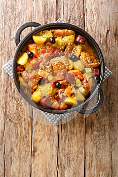 Chinese Galinha a Portuguesa chicken stew with vegetables in coconut curry close-up in a frying pan. Vertical top view photo