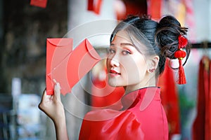 A Chinese girl in a red dress is holding an Qipao envelope