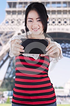 Chinese girl taking picture at Eiffel Tower