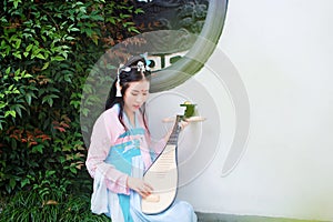 Chinese girl in traditional ancient drama costume hanfu cosplay play flute guitar pipa