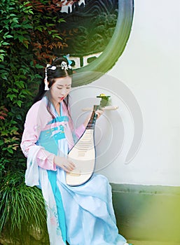 Chinese girl in traditional ancient drama costume hanfu cosplay play flute guitar pipa