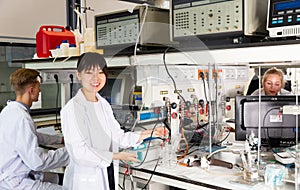 Chinese girl working with reagents in test tubes during chemical experiment