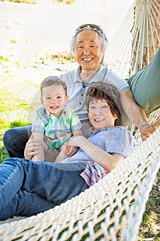 Chinese Grandparents In Hammock with Mixed Race Baby