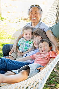 Chinese Grandparents In Hammock with Mixed Race Children