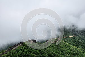 The Chinese Great Wall near Beijing hidden in the thick forest and mist