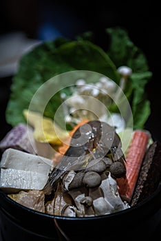 Chinese hotpot with fresh raw prawns, tofu, mushrooms, green leaves for lunch