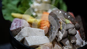 Chinese hotpot with fresh raw prawns, tofu, mushrooms, green leaves for lunch