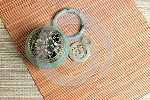 Chinese incense burner, traditional nephrite jewelry and on the bamboo mat background. still-life. copy space