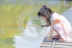 Chinese kid fishing squatting on wooden board