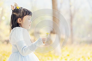 Chinese kid in garden or field with flower in hand