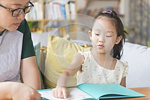 Chinese kid point and read with mom together