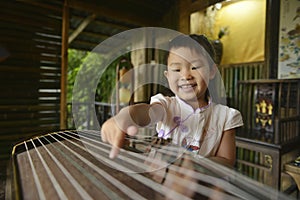 Chinese kid try to playing with traditional Musical instrument