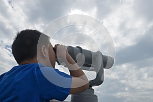 Chinese kid using telescope lookout