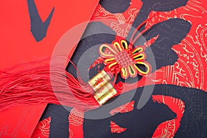 A Chinese knot hanging on the red spring festival couplets with Chinese characters