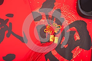 A Chinese knot hanging on the red spring festival couplets with Chinese characters