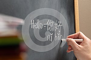 Chinese language learner writing Hello word Nihao in Chinese characters photo