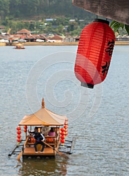 Chinese lanterns and boats in lake with sunset over Ban Rak Thai